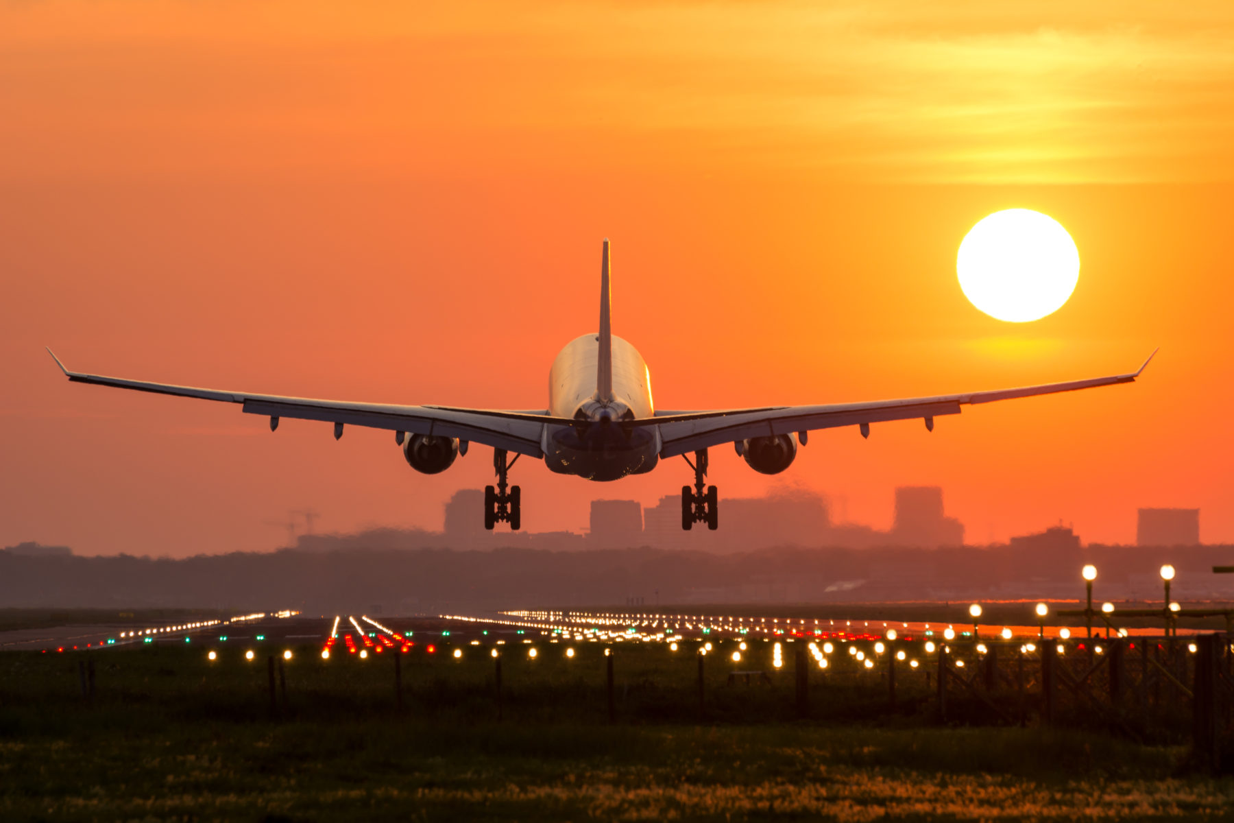 Passenger plane is landing during a wonderful sunrise. Digital